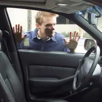 Pessoa olhando para dentro do próprio carro, sem a chave